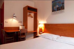 a hotel room with a bed and a table and a desk at Hotel Le 21ème in Strasbourg +8 photos