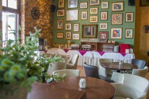 ルトラ・エディプソスにあるIstiaia Hotel Spaの壁に絵画が飾られたテーブルと椅子のあるレストラン