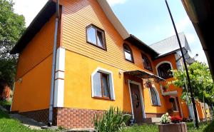 ヤレムチャにあるGuest House Karpatyの黄色とオレンジの家