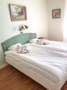 1 cama blanca grande con 2 almohadas en Sjöbo Gästgifvaregård, en Sjöbo