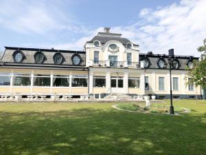 a large white building with a clock on it at Sjöbo Gästgifvaregård in Sjöbo