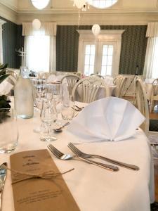 a table with a white table cloth and silverware at Sjöbo Gästgifvaregård in Sjöbo