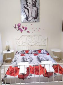 a bedroom with a bed with a picture on the wall at I Cappuccini Rooms in Catania