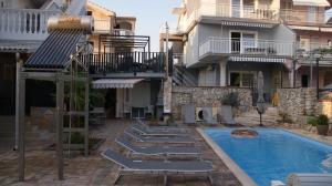 a pool with lounge chairs next to a building at VODICE KRAJE APARTMENTS in Vodice