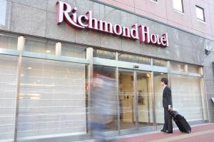 um homem andando em frente a uma loja em Richmond Hotel Hakata Ekimae em Fukuoka