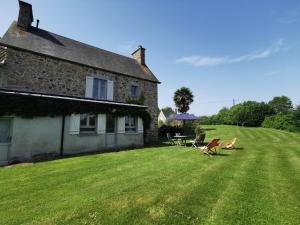 a house with a yard with a table and chairs at La Vallée in Saint-Pierre-Langers