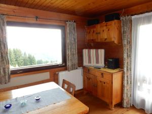 jadalnia ze stołem i oknem w obiekcie Urlaub im Blockhaus w mieście Diex