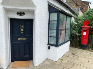 a blue door and a red mailbox in front of a house at The Old Post Office in Whitby