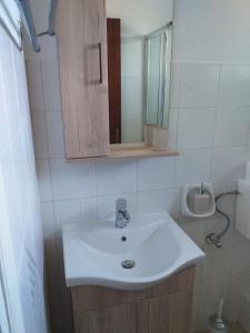 a bathroom with a white sink and a mirror at SAM΄S ROOMS in Corfu Town