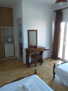 een slaapkamer met een bed, een spiegel en een bureau bij SAM΄S ROOMS in Corfu-stad