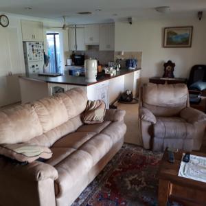 a living room with a couch and two chairs at Comfortable Secure Homeshare in Perth