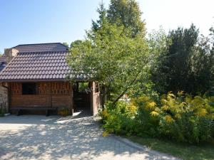 ein Holzhaus mit einem Zaun und einigen Büschen in der Unterkunft Agroturystyka Nad Bugiem Szuminka in Szuminka