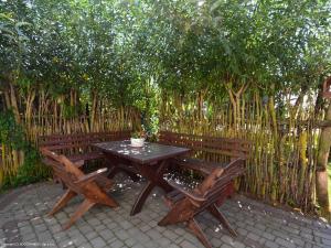 a wooden picnic table and two chairs in front of a fence at Agroturystyka Nad Bugiem Szuminka in Szuminka +7 photos