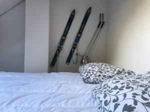 a bedroom with a bed and some skis hanging on the wall at Grand T3 en duplex pour 6 avec parking couvert in Cauterets