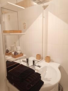 a white bathroom with a sink and a mirror at Park de Vincennes in Pau