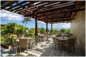 ein Restaurant mit Tischen und Stühlen auf einer Terrasse in der Unterkunft d'Nusa Beach Club and Resort in Nusa Lembongan