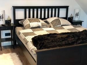 ein Bett mit einer schwarzen und weißen Decke und Kissen in der Unterkunft Ferienwohnung Hünzingen in Walsrode