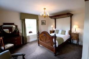 a bedroom with a bed and a dresser and a window at The Morritt Hotel in Barnard Castle