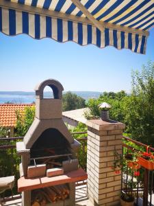 a outdoor pizza oven under an umbrella on a patio at Apartment Eden in Crikvenica