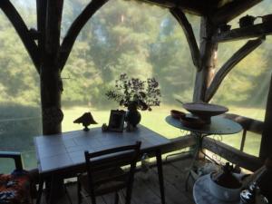 a table in a room with a large window at Touvent maison au milieu des bois in Savignac-de-Miremont