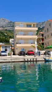 un bâtiment à côté d'une masse d'eau dans l'établissement Apartments Gaston, à Podgora