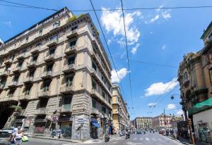 wysoki biały budynek przy ulicy miejskiej w obiekcie Dante Maison de Prestige w mieście Neapol