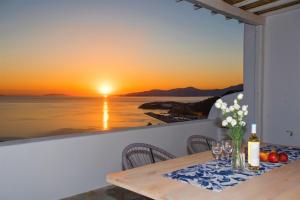 una mesa con vistas al océano al atardecer en Sugar Blue, en Mykonos ciudad