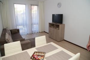 a living room with a couch and a tv at Морски Бряг in Sveti Vlas