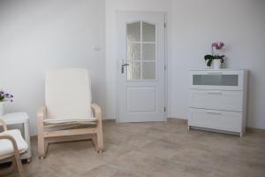 ein weißes Zimmer mit einer weißen Tür und einem Stuhl in der Unterkunft Apartmán U Fuxů in Žleby