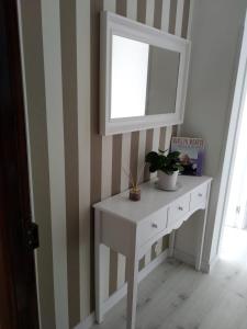 a white dressing table with a mirror on a wall at EL RINCON DE CRISTINA in Perlora