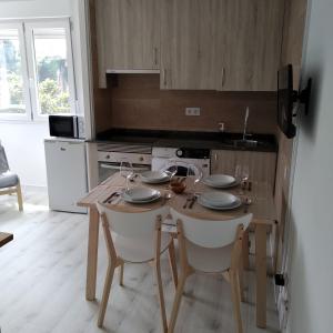 a kitchen with a wooden table with chairs and a table at EL RINCON DE CRISTINA in Perlora