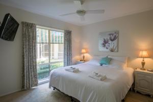 a bedroom with a large white bed with two towels on it at The Birch House - Silver Birches Accommodation Bright in Bright