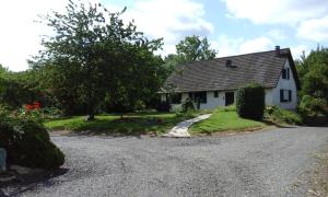 a white house with a gravel driveway at 3 chambres spacieuses du grès rouge in Beauval