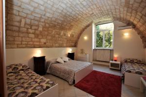 ラグーザにあるLe Fioriere Affittacamere e Casa vacanzeのレンガの壁、ベッド2台が備わるベッドルーム1室が備わります。