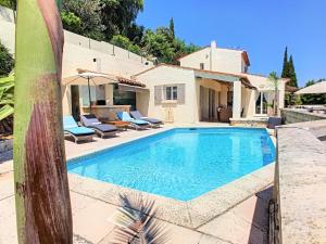 芒德留拉納普勒的住宿－3 Bedrooms Villa near Cannes - Pool & Jacuzzi - Sea View，一个带椅子的游泳池以及一座房子