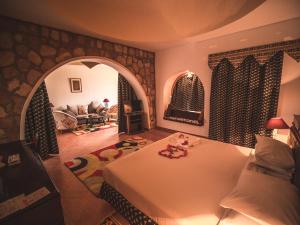 1 dormitorio con 1 cama y sala de estar en Seti Abu Simbel Lake Resort en Abu Simbel