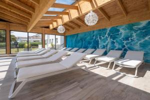 a room with white chairs and a blue wall at Thalacap Île de Ré - Thalasso & Spa in Ars-en-Ré