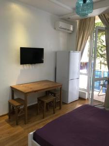 アドレルにあるМое летоの木製テーブル、壁掛けテレビが備わる客室です。