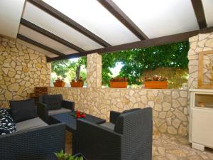 patio z krzesłami i kamienną ścianą w obiekcie Apartment Alenka 1930 w mieście Banjole