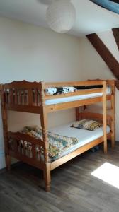 オルブールにあるChez Marguerite Gîtes à la fermeの天井の客室で、木製の二段ベッド2台が備わります。