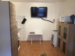 アウクスブルクにあるMonteurezimmerの壁にテレビが付いた小さな部屋