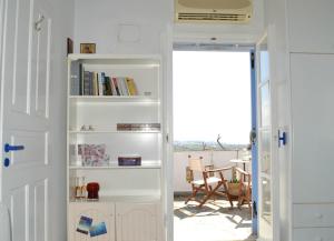 una puerta que conduce a una habitación con una estantería de libros en Villa Vrachos en Agios Prokopios