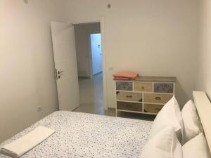 biała sypialnia z łóżkiem i komodą w obiekcie Luda kuća w Barze
