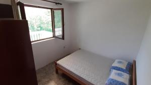 una piccola camera da letto con un letto e una finestra di Apartman Tešović a Kotor (Cattaro)