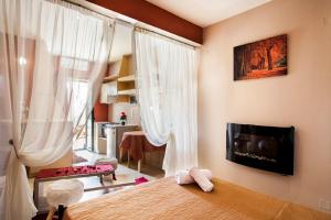 a bedroom with a bed and a tv on a wall at Estate Kares in Tílisos