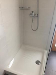 ducha blanca con cabezal de ducha y bañera en Apartma Pika, en Mojstrana