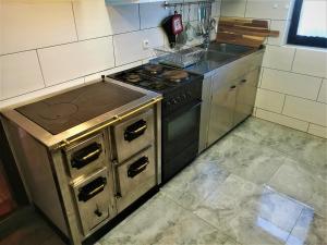 Il comprend une cuisine équipée d'une cuisinière ancienne et d'un évier. dans l'établissement Vinska klet Smej, à Lendava