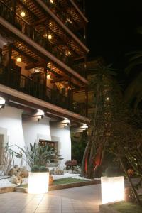 un gran edificio con balcón y algunas plantas en Hotel La Carolina en Lloret de Mar