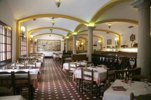 um restaurante com mesas e cadeiras num quarto em Hotel La Carolina em Lloret de Mar