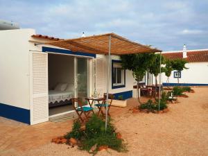 uma casa com um pátio com uma cama e um guarda-chuva em Quinta do Maranhão em Lagos